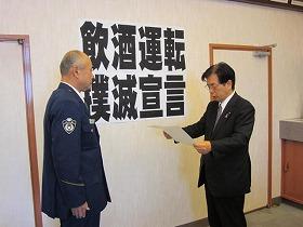 田代町長が警官に紙を読みながら飲酒運転撲滅宣言をしている写真