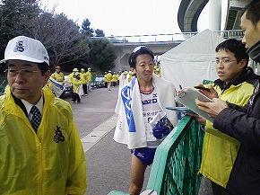 マラソン選手に話しかける男性スタッフ