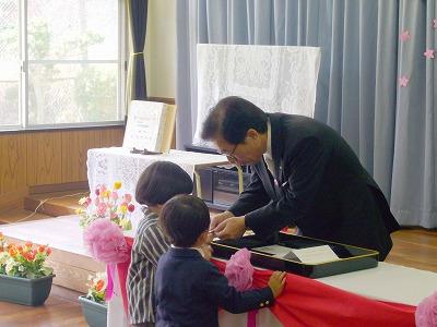 子どもたち一人一人に終了証書と缶バッチを手渡す田代町長