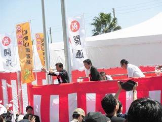 開通式典で餅まきをする田代町長