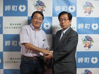 手を取り合う南出雅之さんと田代町長