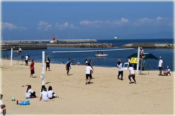砂浜でビーチバレーの試合をしている写真