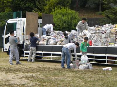 学校のグラウンドを使って地域のみんなで廃品回収をしている写真