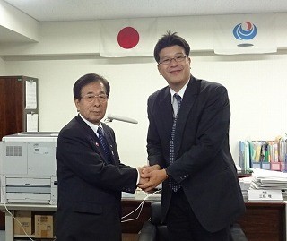 三島近畿地方整備局大阪空港整備事務所長と握手する田代町長