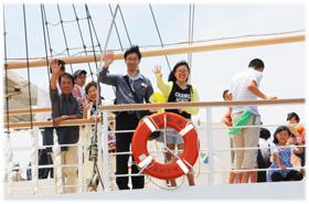 船から手を振る親子の写真