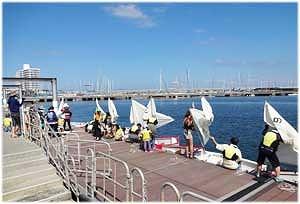 参加者がそれぞれの小型ヨットの帆を組み立てる様子の写真
